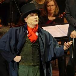 Musikvermittlung Stuttgart . Schauspielr auf der Bühne mit rotem Schal und Zylinder